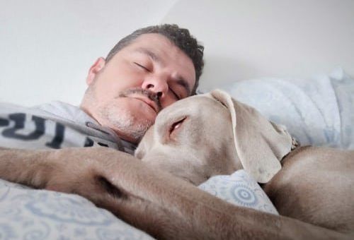 hombre y perro durmiendo